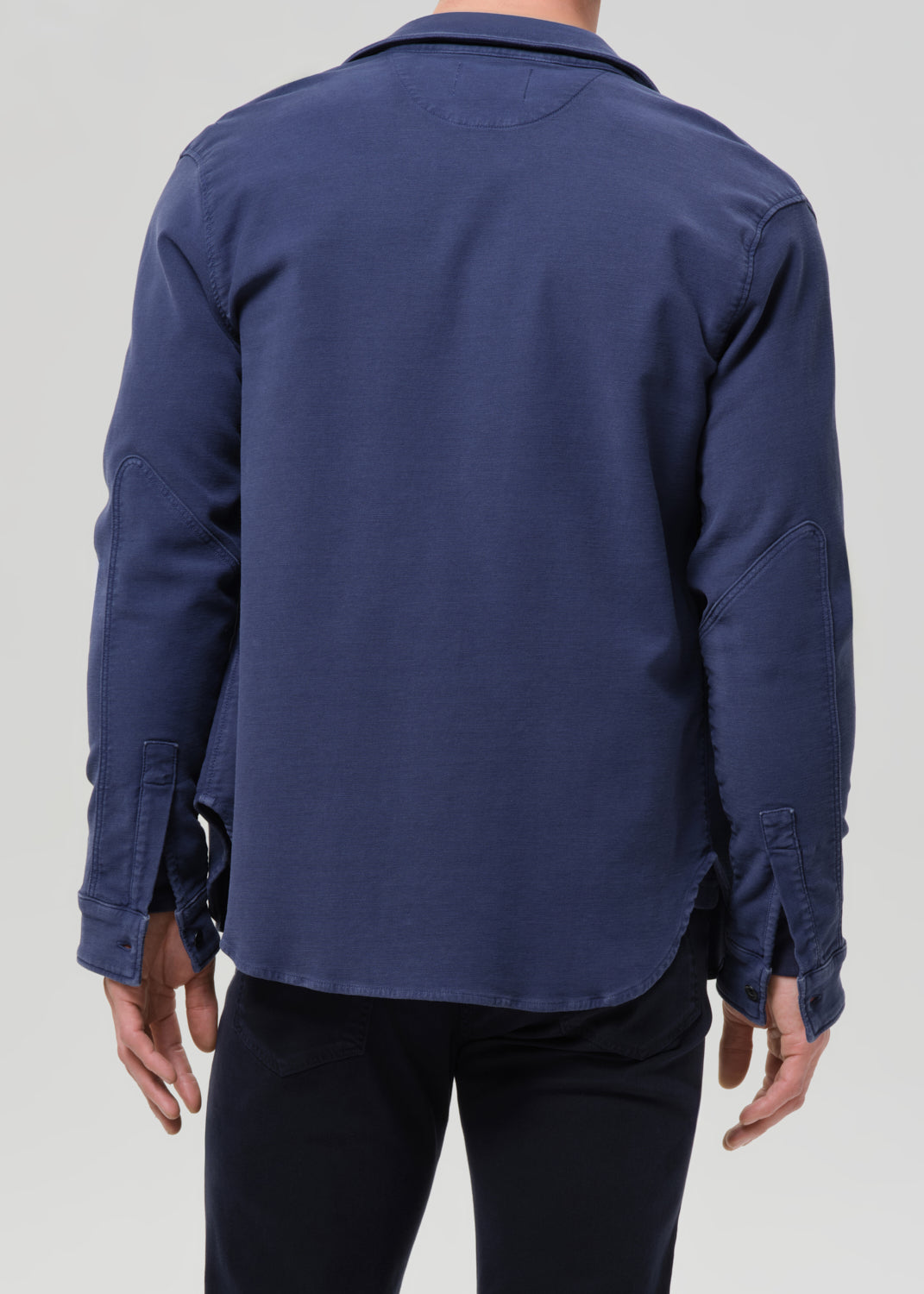 Navy blue shirt worn by a person on a grey background