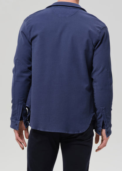Navy blue shirt worn by a person on a grey background