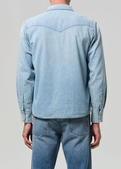 Light blue denim shirt and jeans on a plain background
