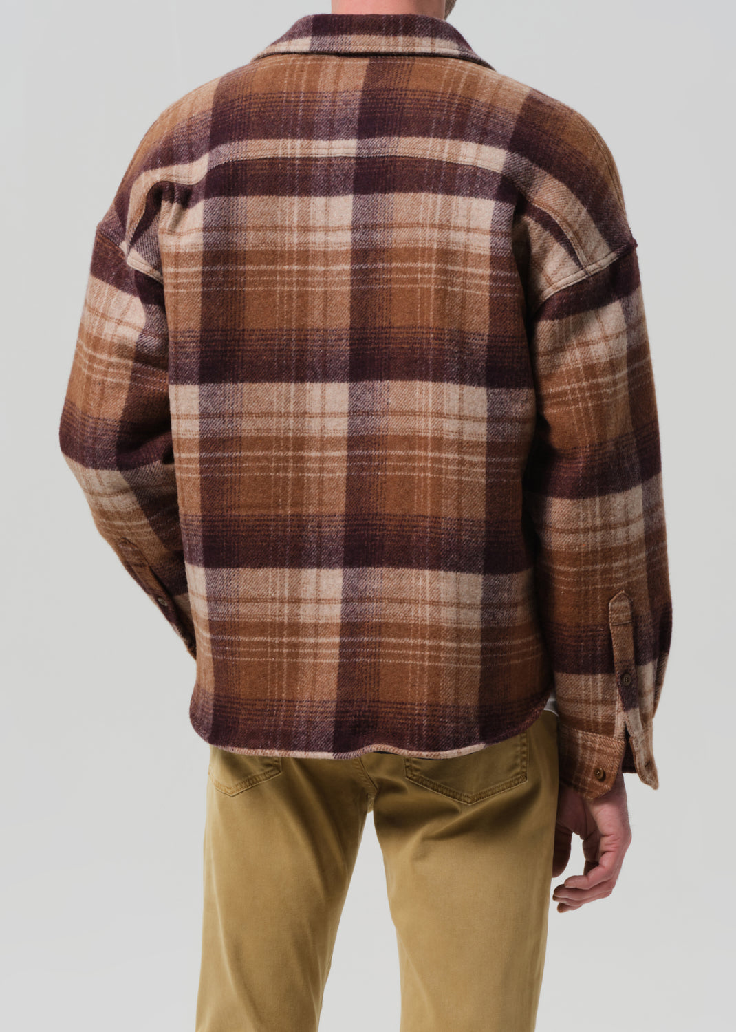 Plaid shirt worn by a person on a neutral background