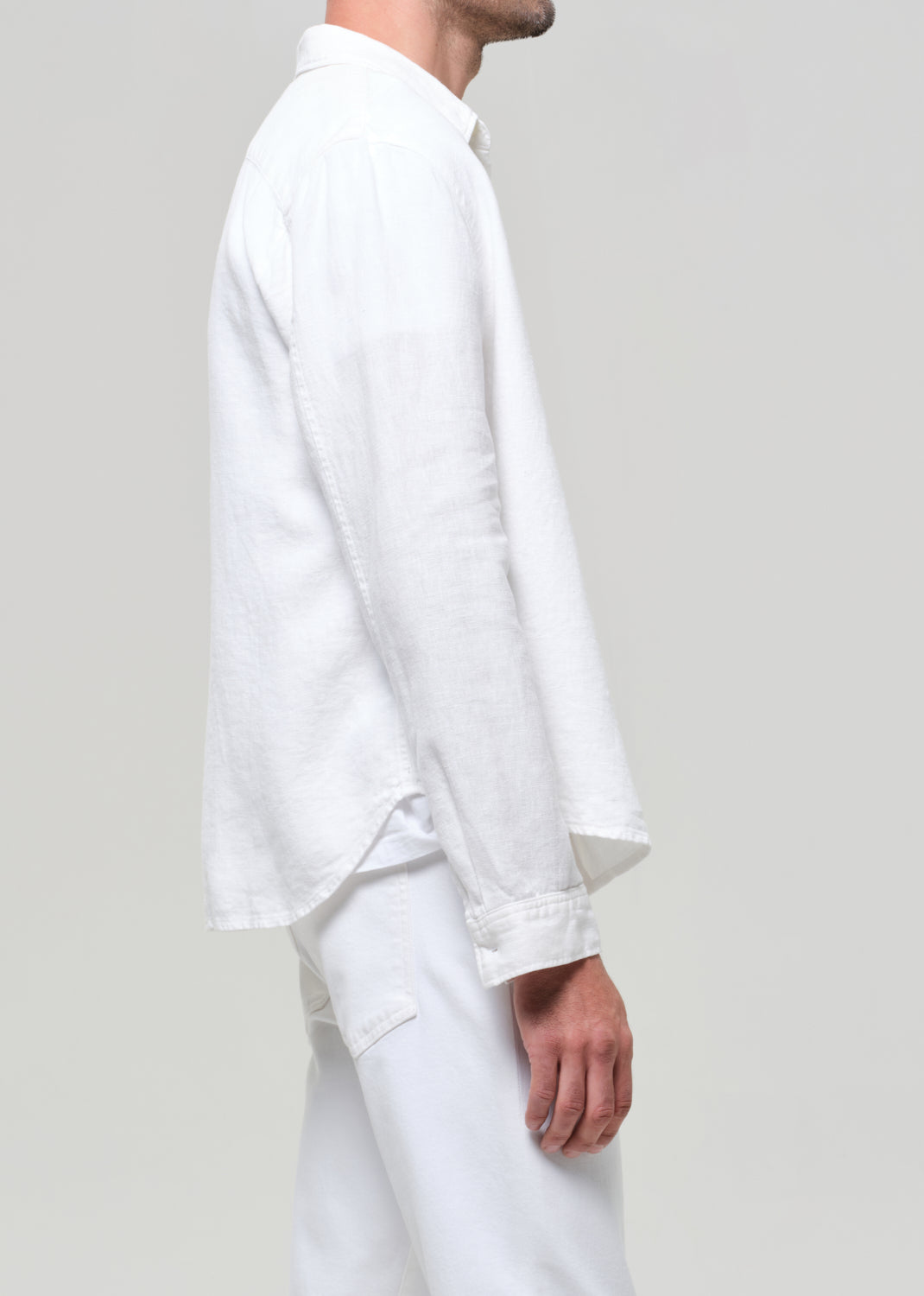 Person wearing a white shirt and pants on a plain background