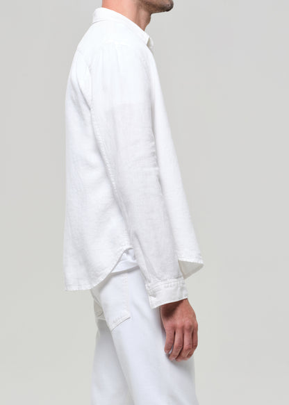 Person wearing a white shirt and pants on a plain background