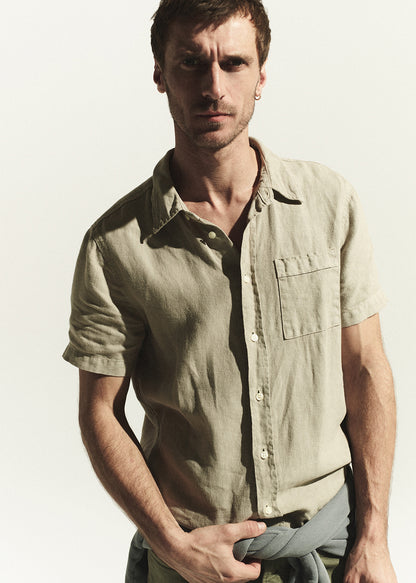 Man wearing a light beige shirt against a plain background