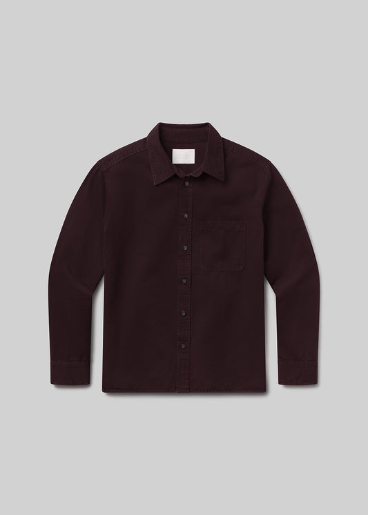 Flat lay of dark red button-up shirt on a grey background