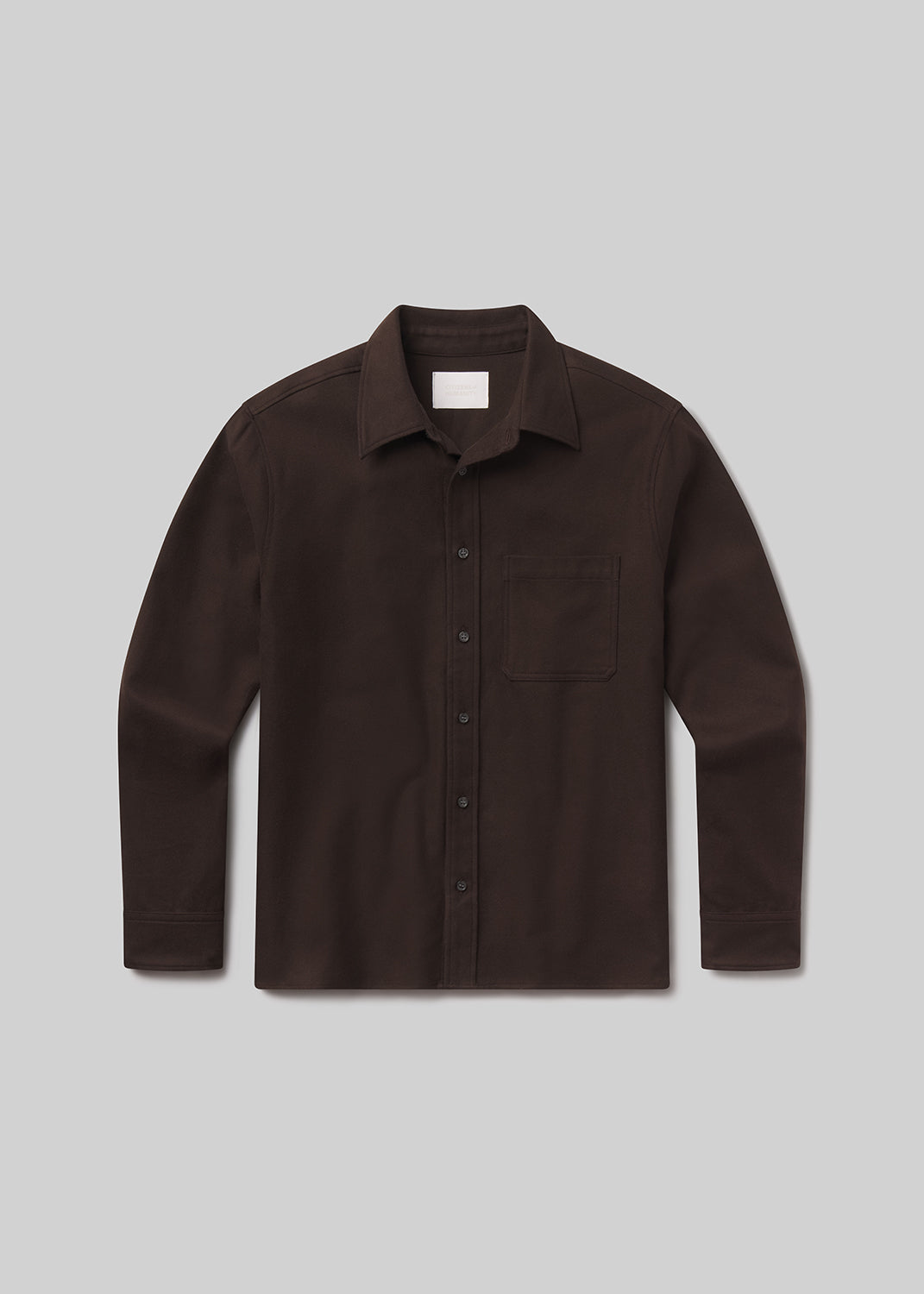 Flat lay of brown shirt on a grey background