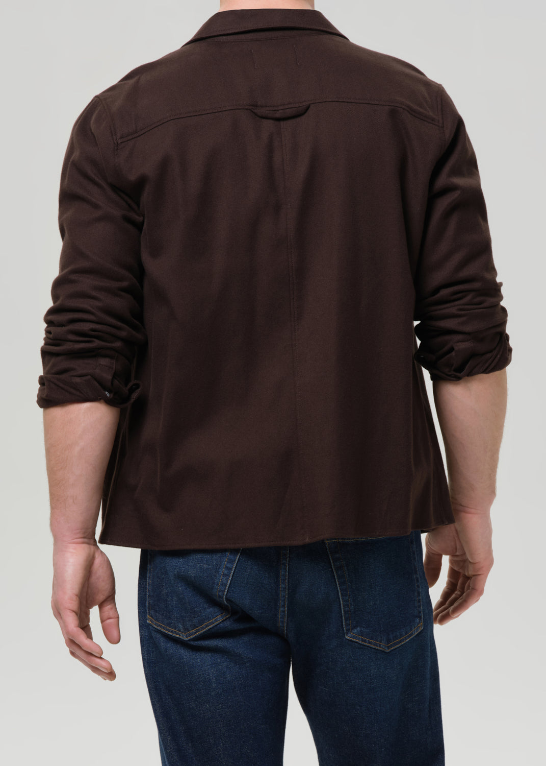 Brown shirt worn by a person on a grey background