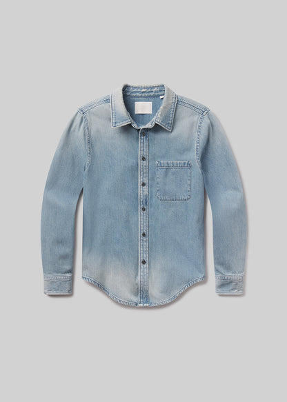 Flat lay of blue denim shirt on a grey background