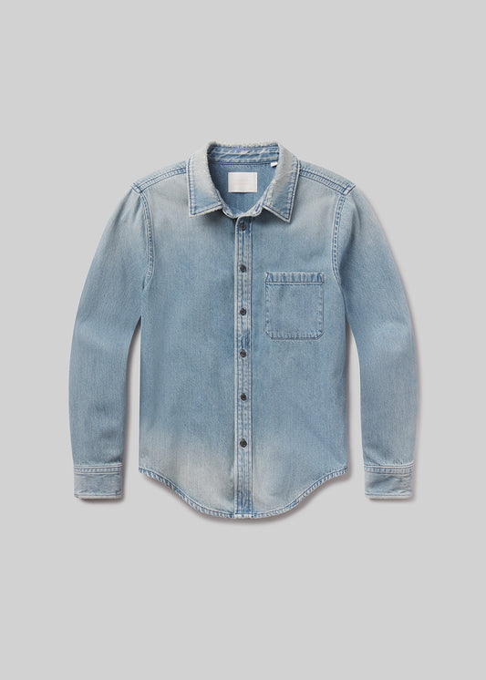 Flat lay of blue denim shirt on a grey background