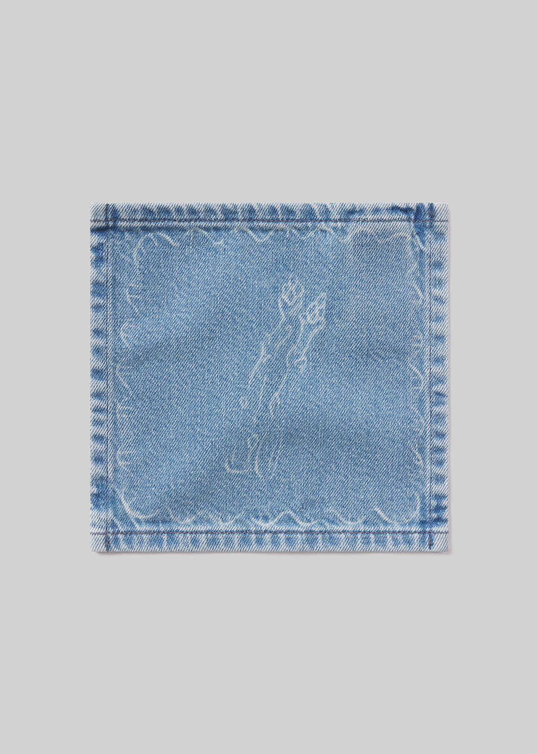 Denim cocktail napkin with asparagus embroidered design on a light gray background