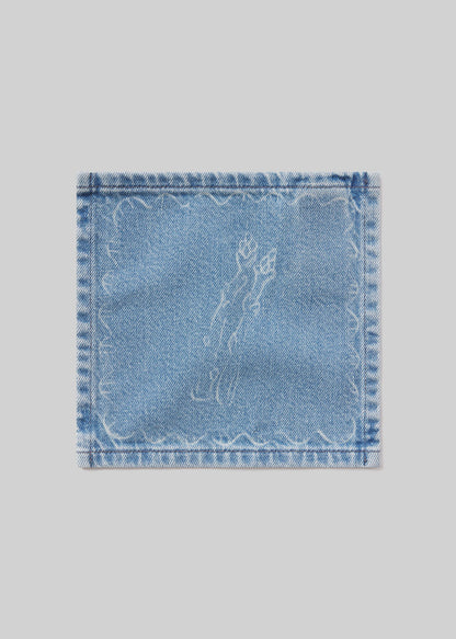 Denim cocktail napkin with asparagus embroidered design on a light gray background