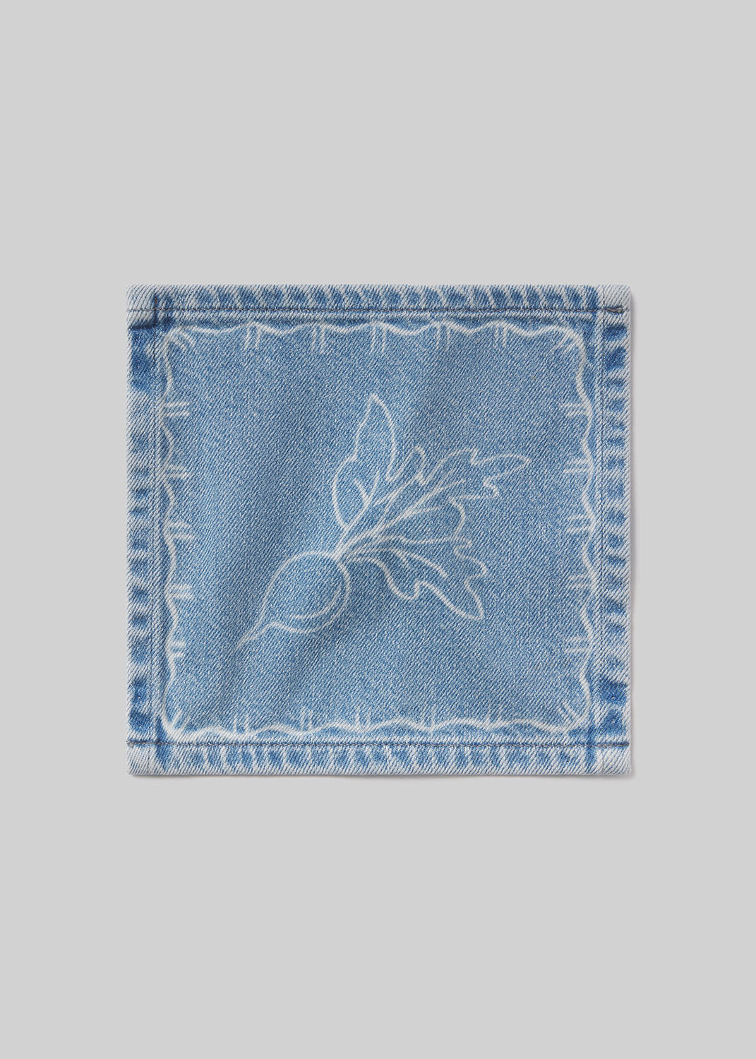 Denim cocktail napkin with beet embroidered design on a light gray background