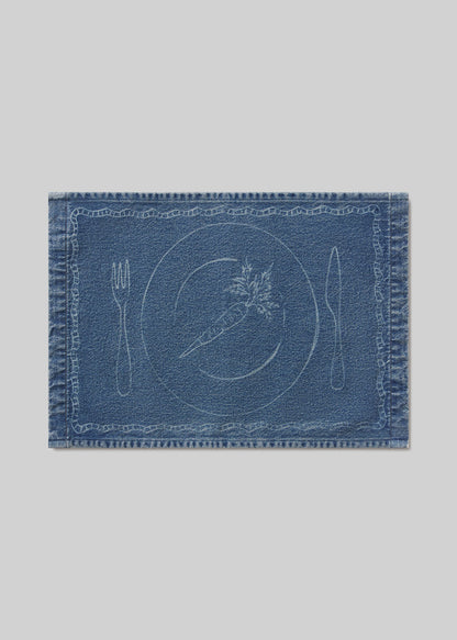 Blue denim placemat with carrot ,cutlery and plate design on a light gray background