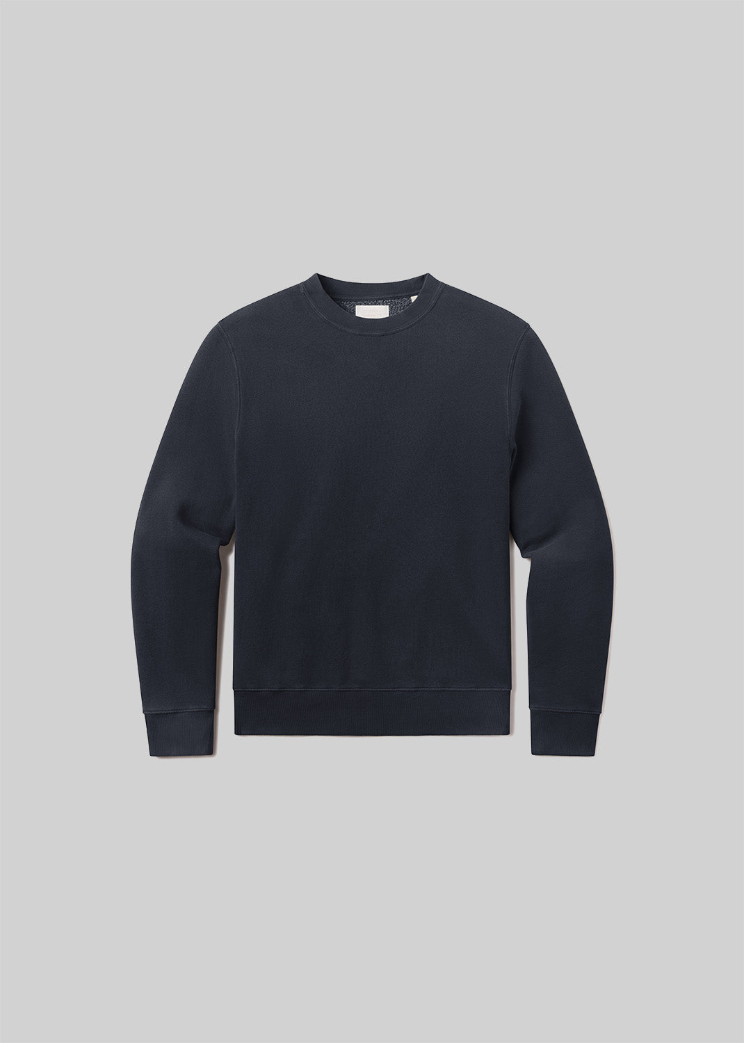 Flat lay of black sweatshirt on a grey background