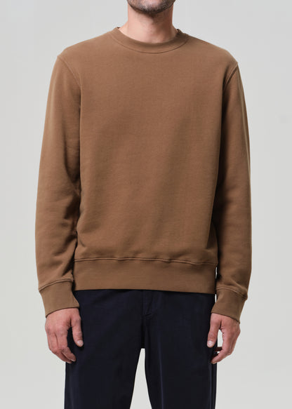 Brown sweatshirt worn by a person on a plain background
