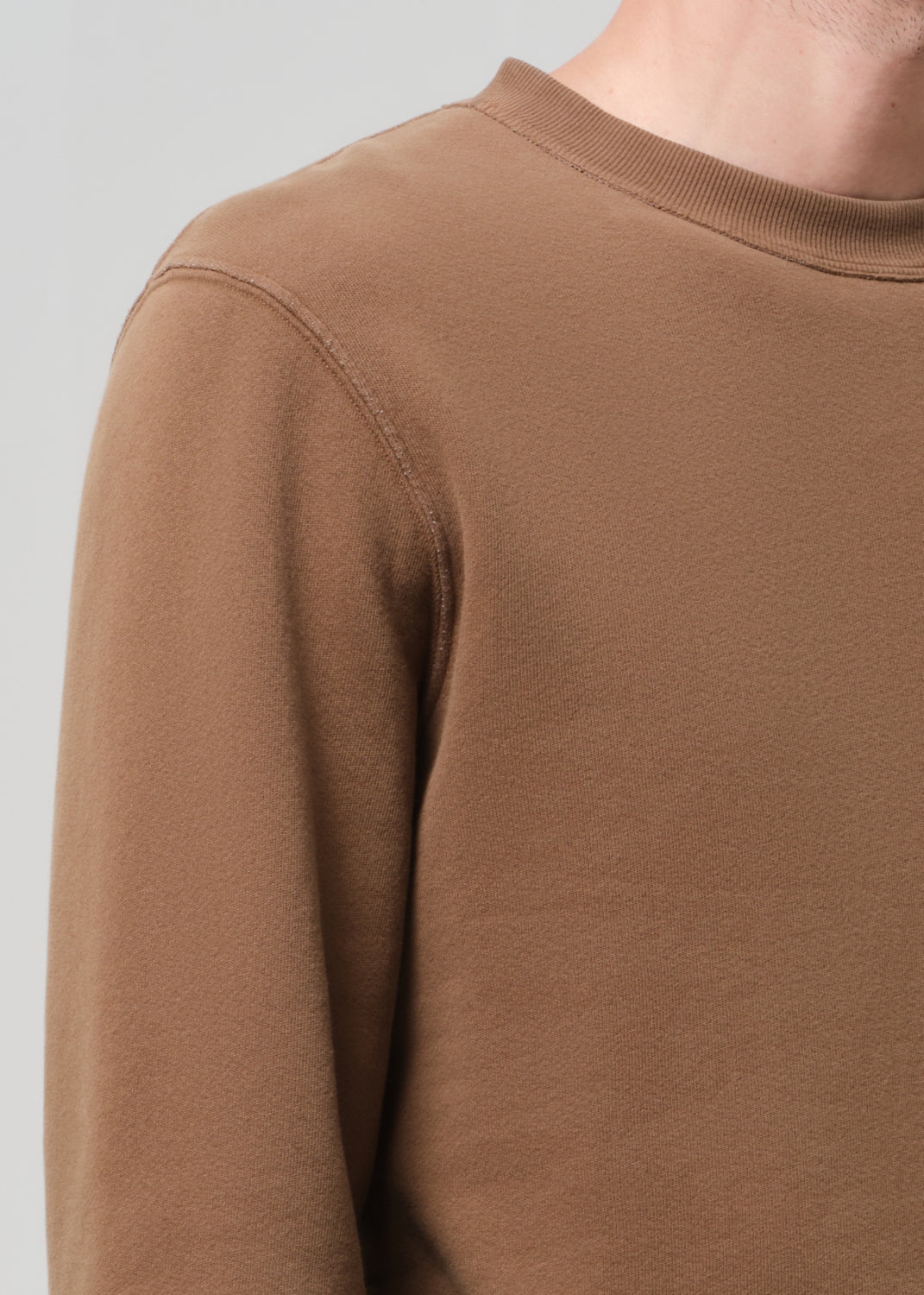 Close-up of a brown sweatshirt on a plain background