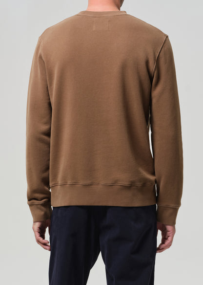 Brown sweatshirt worn by a person on a plain background