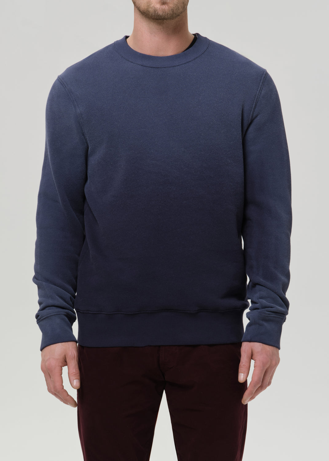 Person wearing a navy blue sweatshirt on a grey background