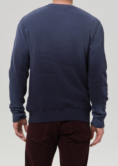 Person wearing a navy blue sweatshirt on a grey background