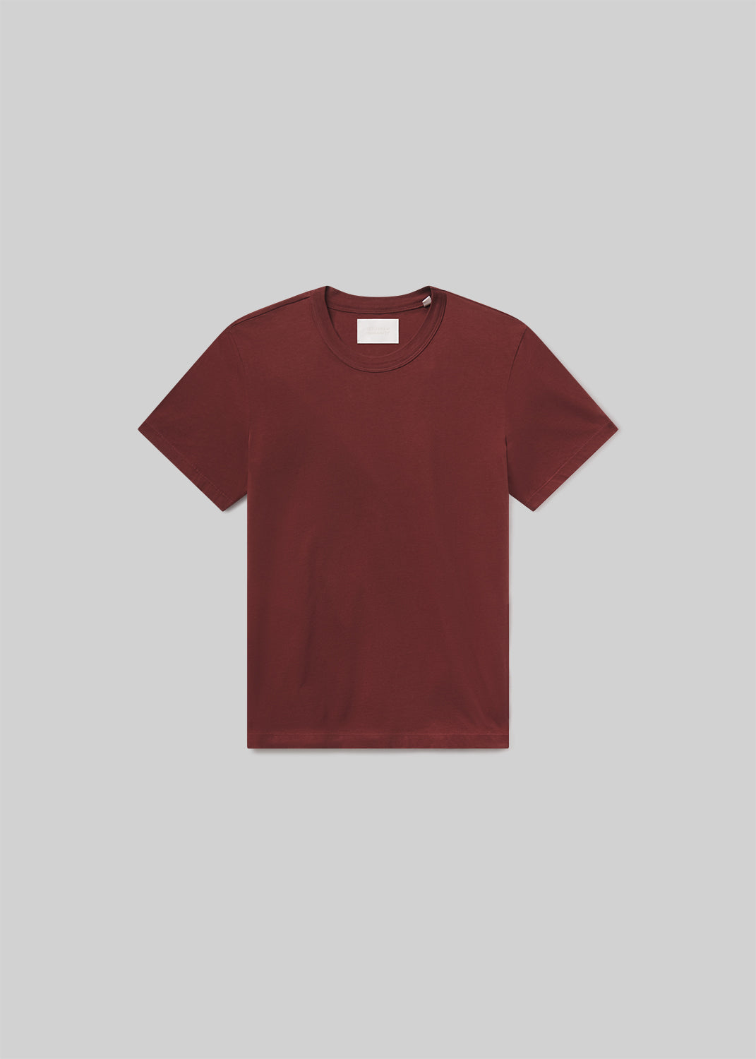 Flat lay of maroon t-shirt on a grey background