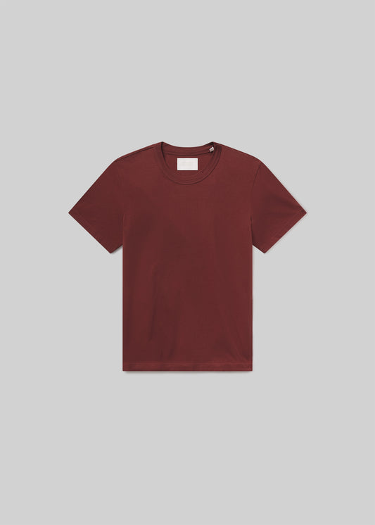Flat lay of maroon t-shirt on a grey background