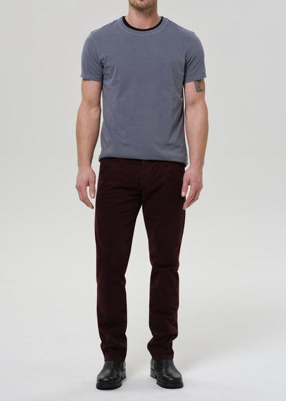 Person wearing a gray t-shirt and dark pants on a white background