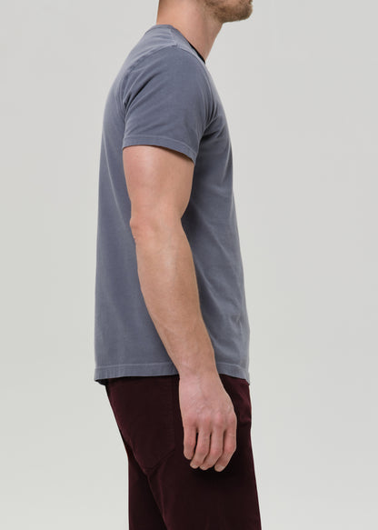 Person wearing a gray t-shirt and maroon pants on a light gray background