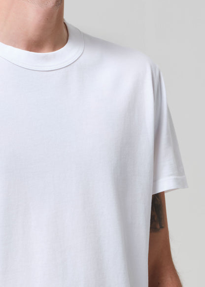 White t-shirt worn by a person on a plain background