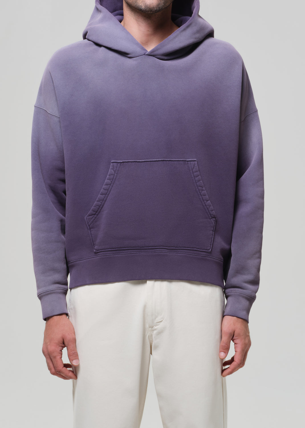 Person wearing a purple hoodie on a plain background