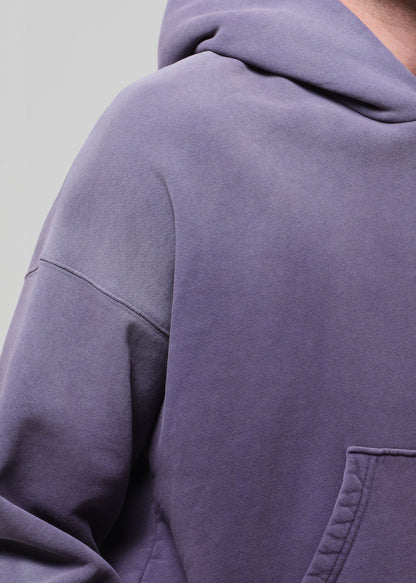 Close-up of a person wearing a purple hoodie with a neutral background