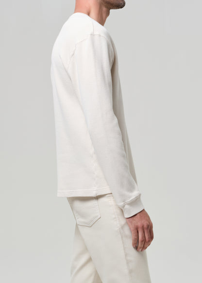 Person wearing a white long-sleeve shirt and pants on a light gray background