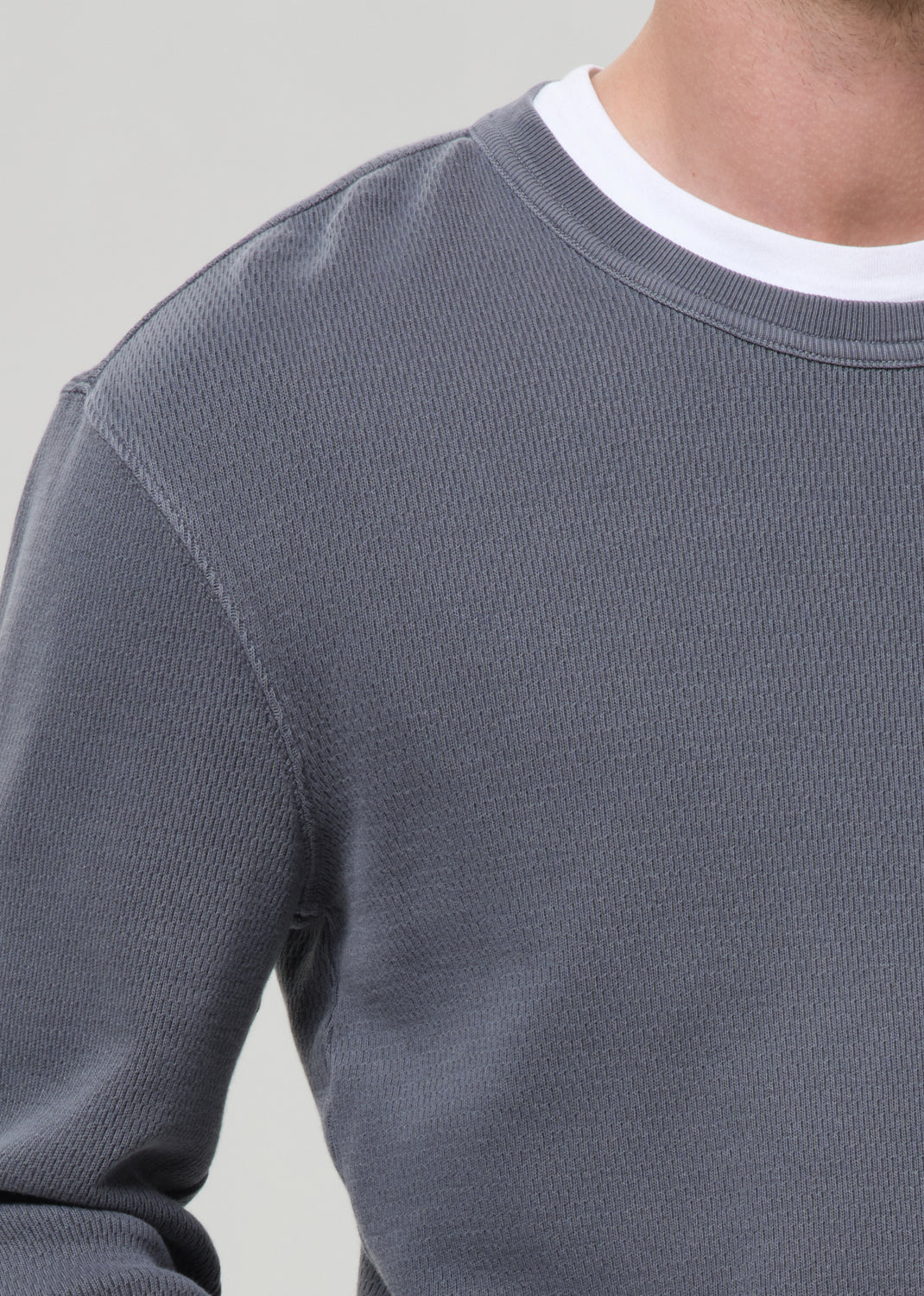 Grey sweatshirt worn by a person on a grey background