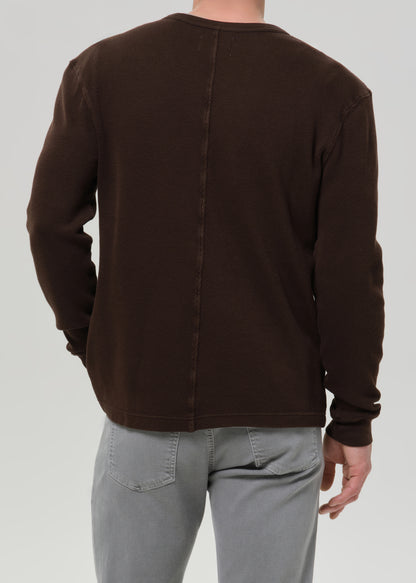 Person wearing a brown jacket on a grey background