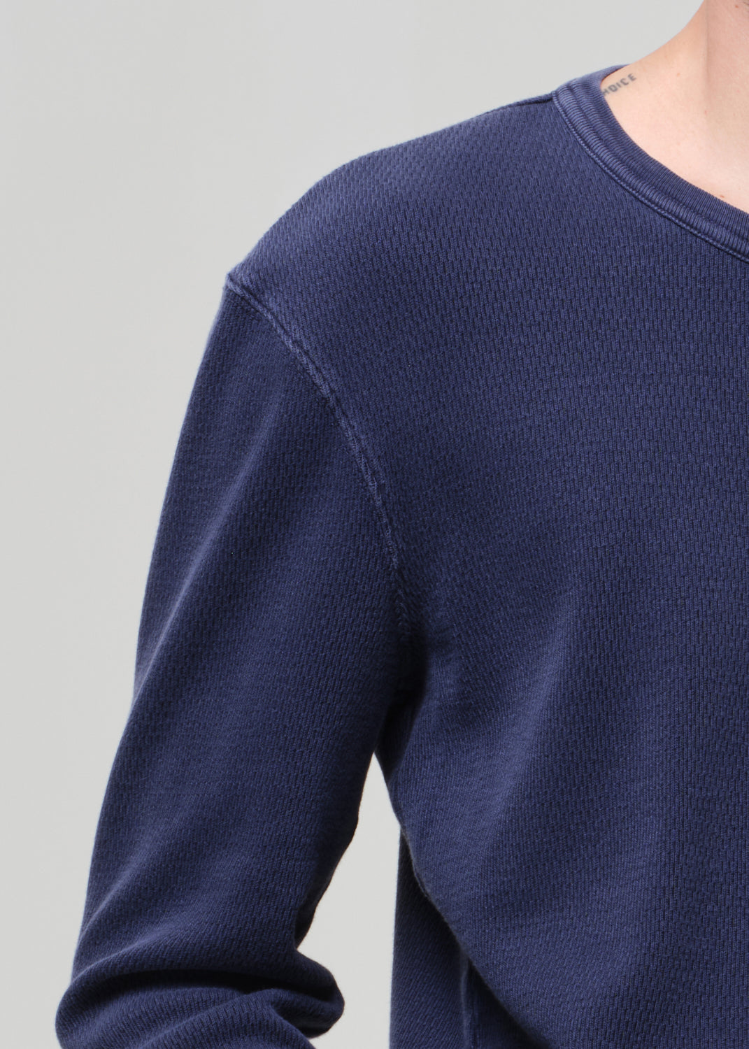 Navy blue sweater on a gray background