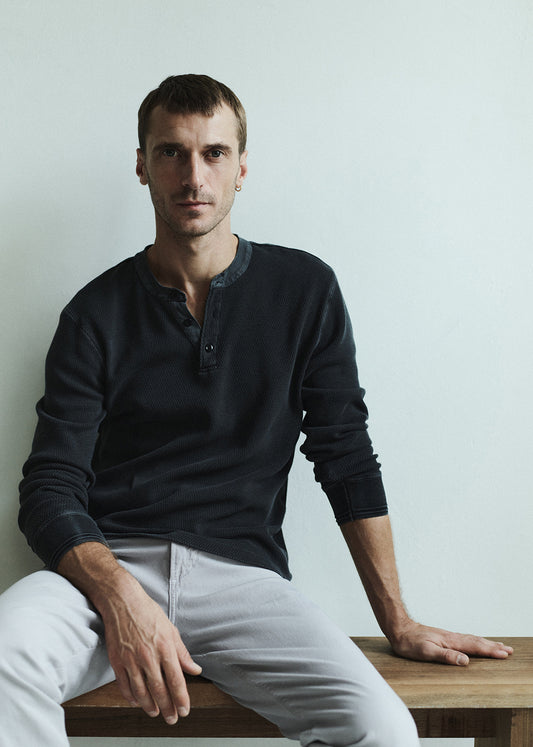 Person wearing dark grey henely paired with light pants