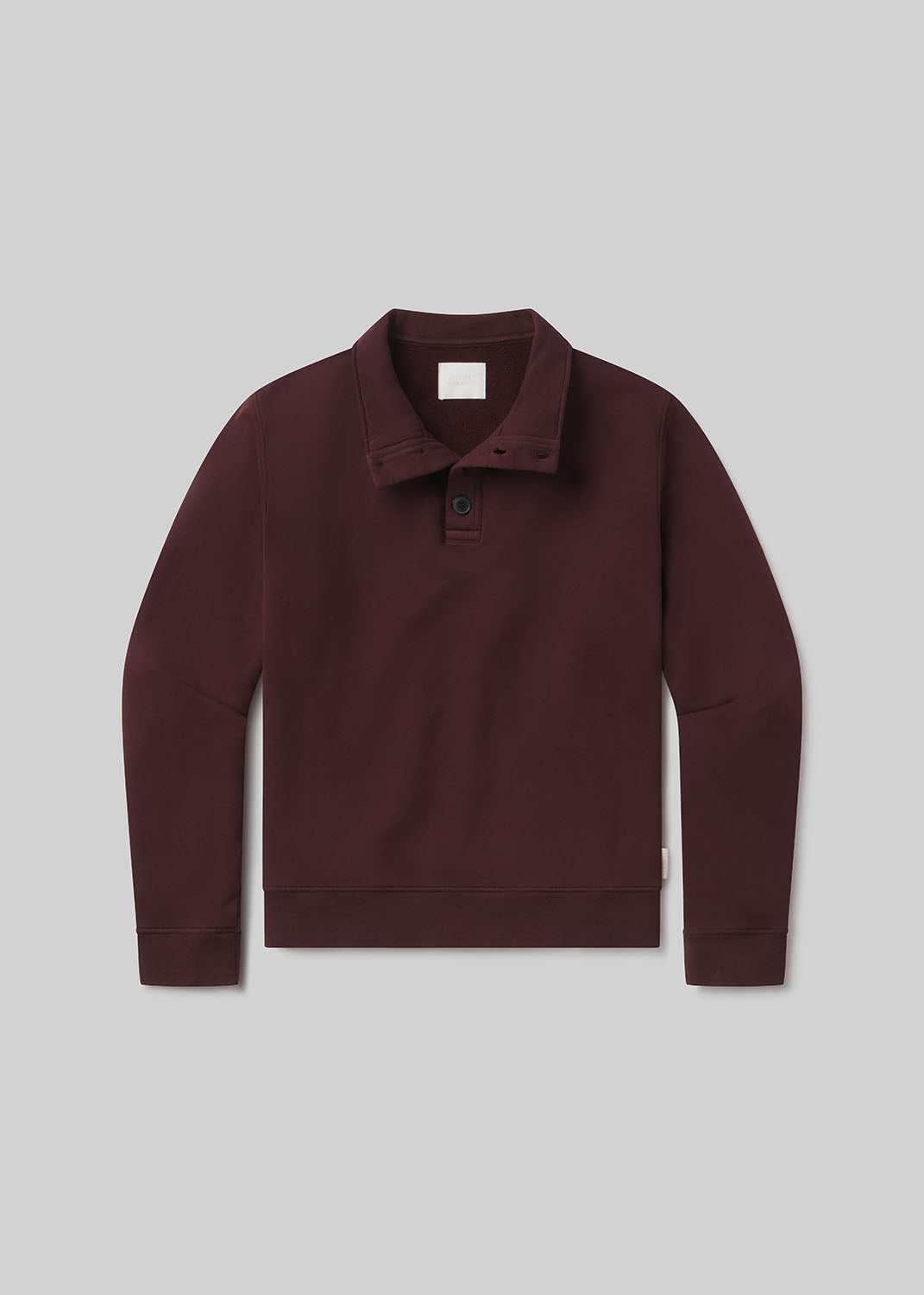 Burgundy half-button pullover on grey background