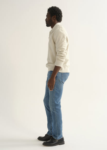 Person wearing cream rugby pullover and blue jeans back