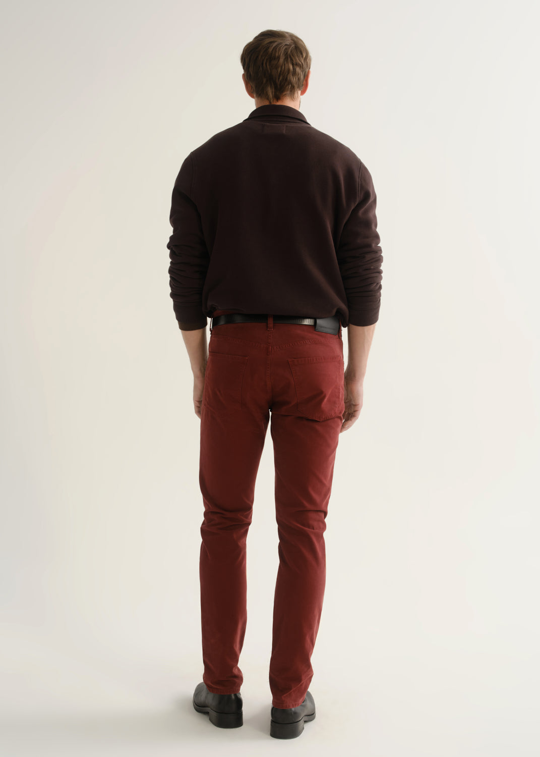 Person wearing dark brown rugby pullover and burgundy pants back