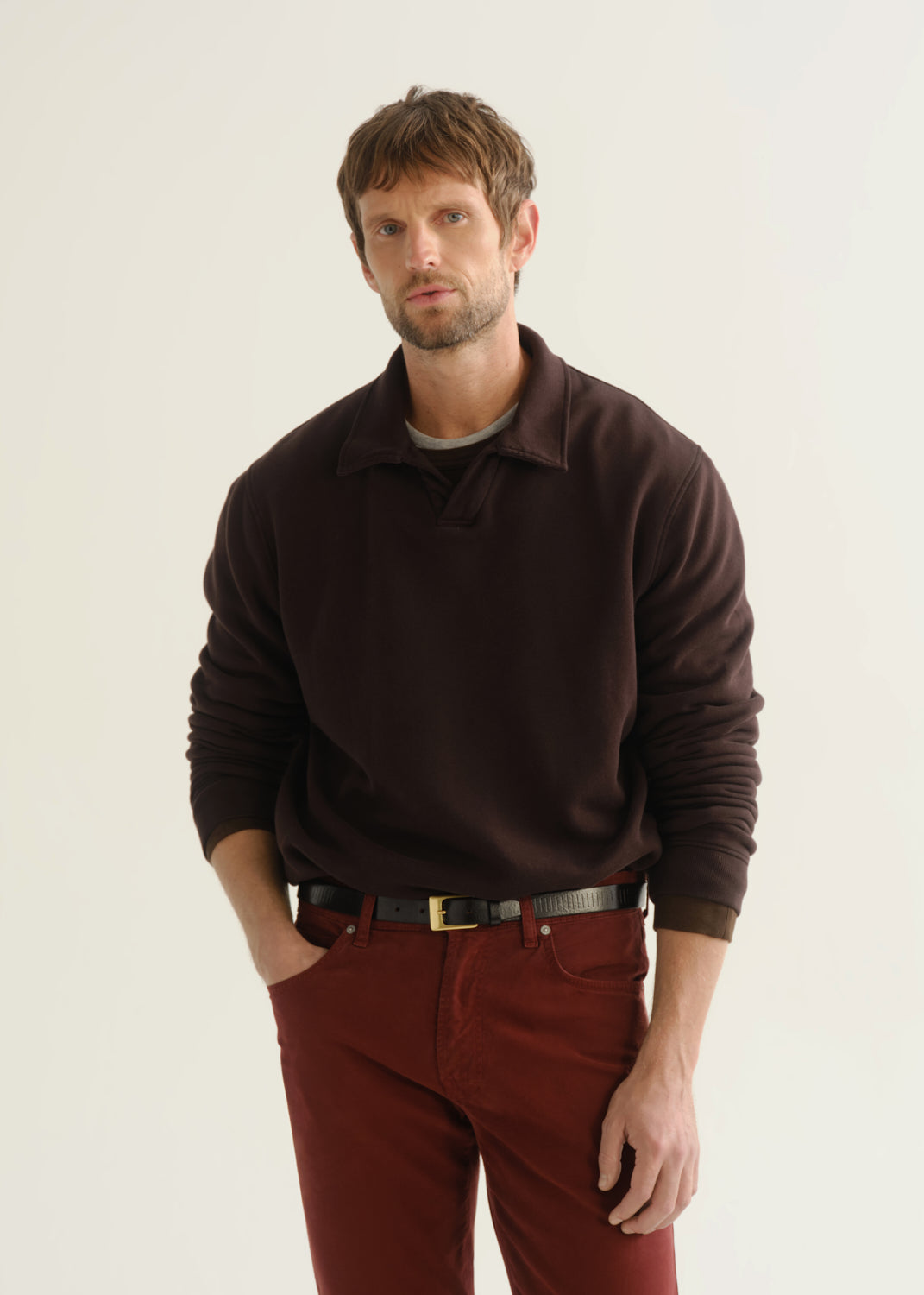 Person wearing dark brown rugby pullover and burgundy pants front crop