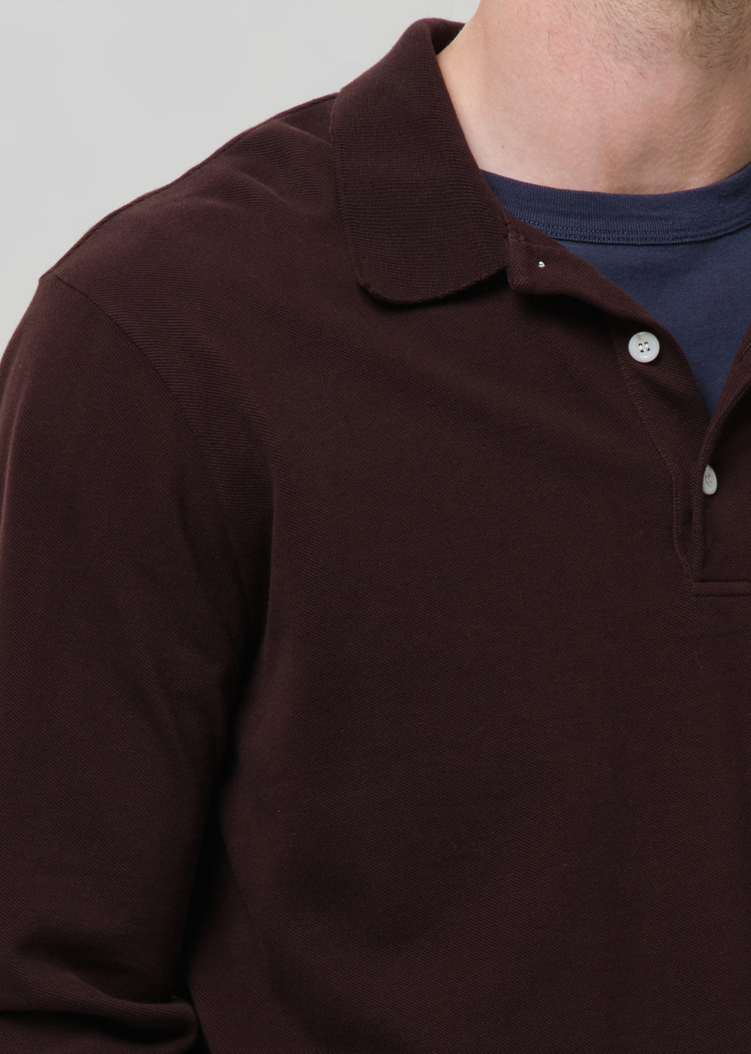 Close-up of a brown long-sleeve polo shirt with a collar.