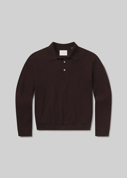 Flat lay of brown long-sleeve polo shirt on a grey background