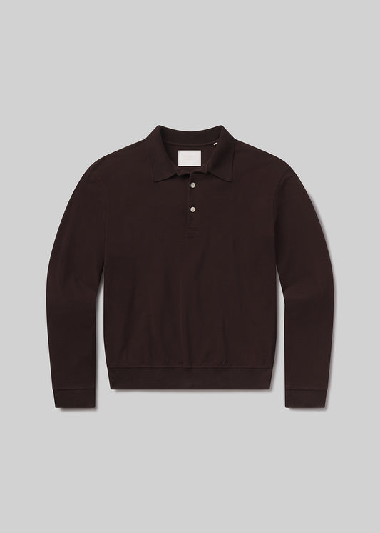 Flat lay of brown long-sleeve polo shirt on a grey background
