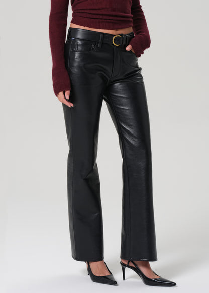 Person wearing black leather pants on a white background